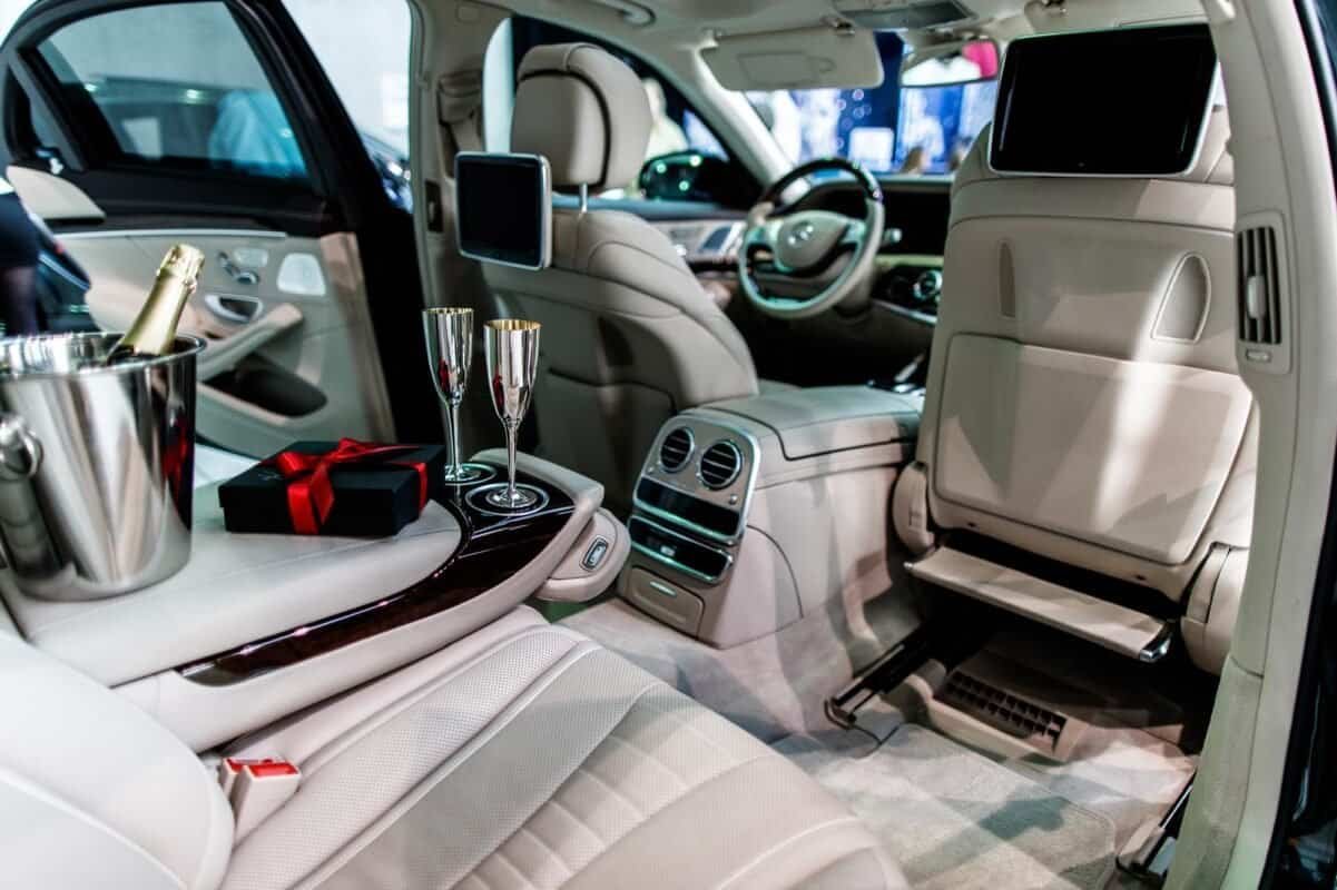 Luxury vehicle interior with champagne, glasses, and celebration setup.
