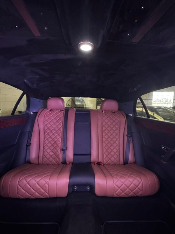 Luxury car interior with quilted leather seats and ambient lighting.