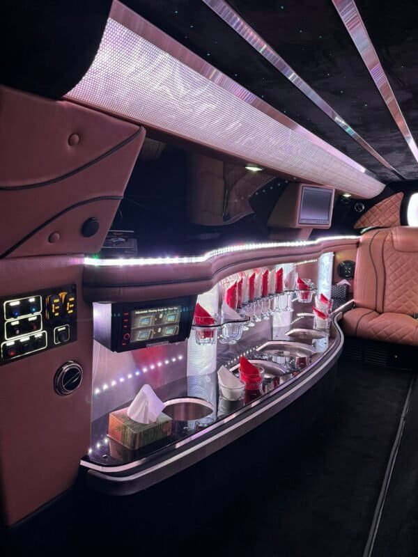 Luxury limousine interior with ambient lighting and plush seating.