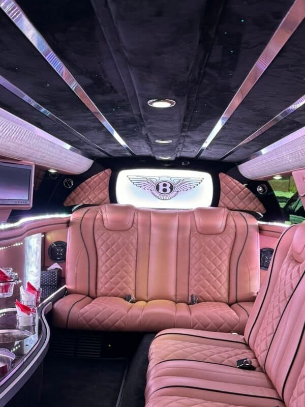 Luxury car interior with plush pink leather seats and ambient lighting.