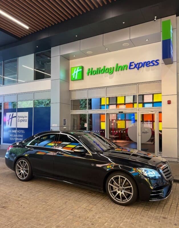 Holiday Inn Express hotel entrance with a luxury car parked outside.