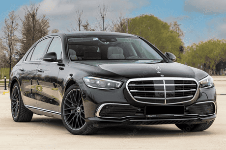 Black Mercedes-Benz luxury sedan parked outdoors with trees in background.